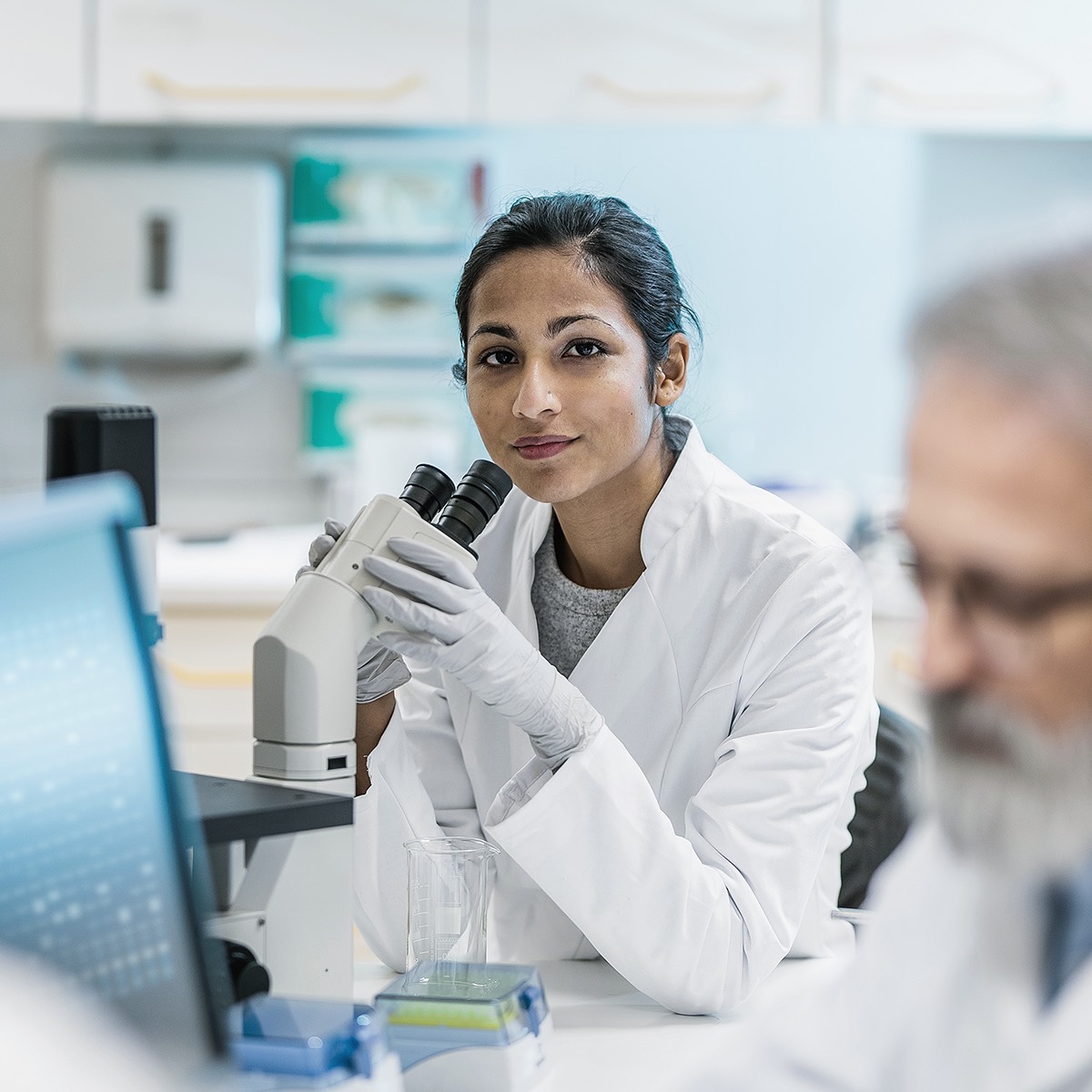 Lab technician looking into microscope